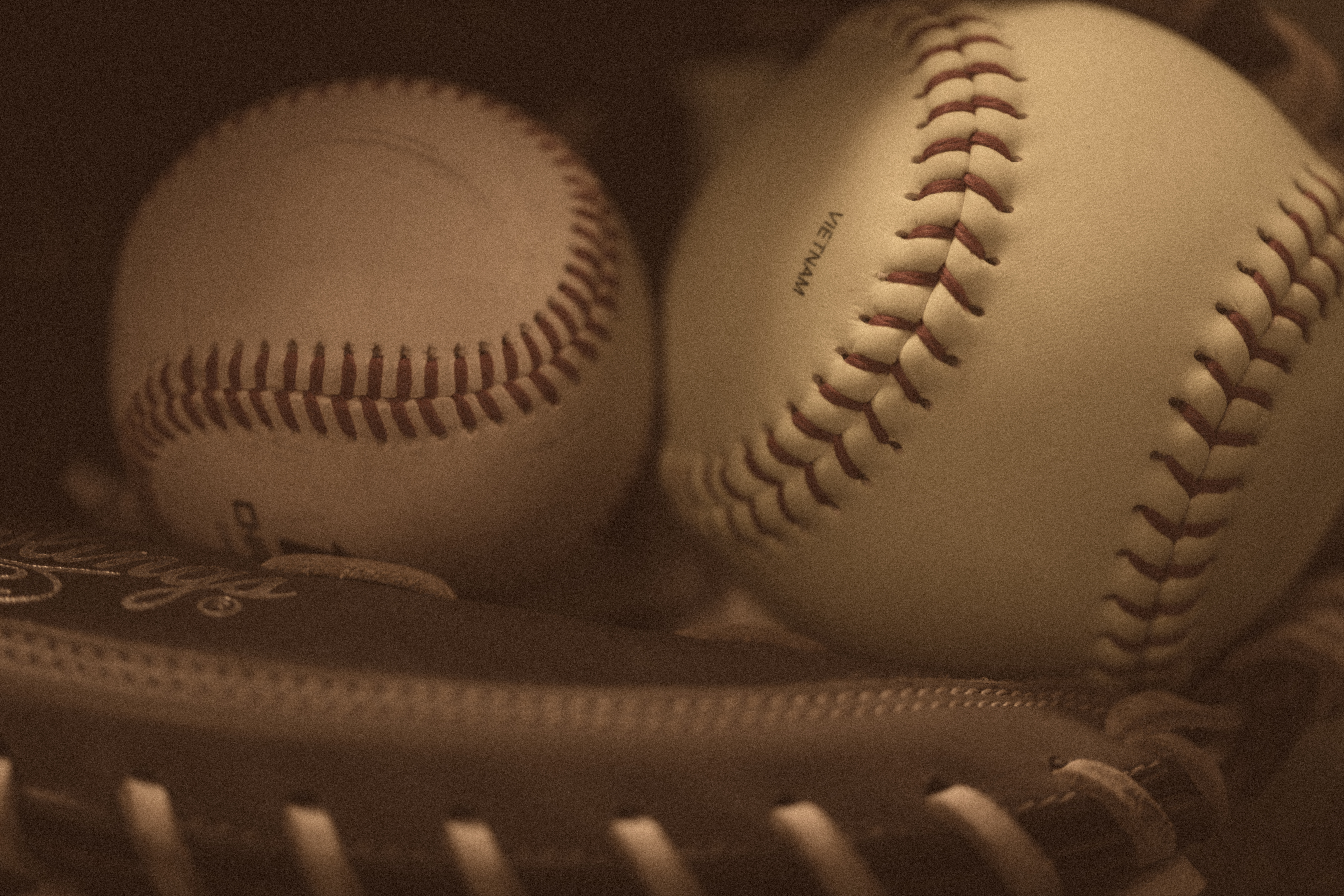 Baseball and softball together in a glove